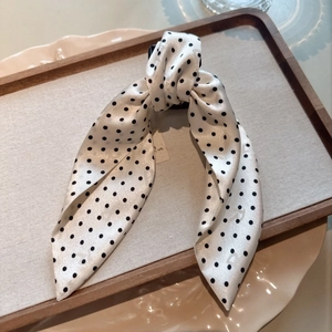 Detailed view of white polka dot fabric bow clip on an elegant wooden serving tray