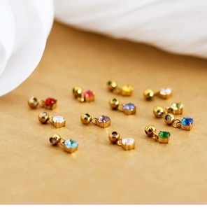 Close-up of 18K gold plated mini zodiac birthstone pendants in various vibrant colors