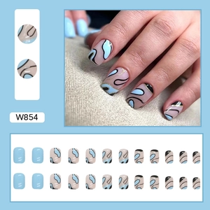 Short wavy blue and beige press-on nails with abstract black lines and gold glitter