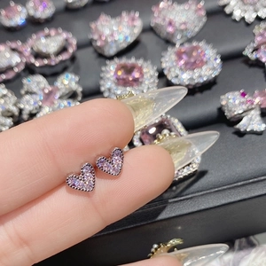 Macro view of heart-shaped earrings with micro-pave pink cubic zirconia stones