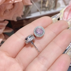 Macro shot of circular pink gemstone earrings with 18K gold plating and pave diamonds