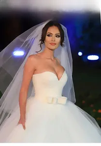 Détail d'une robe de mariée blanche à paillettes avec décolleté en cœur et grand nœud