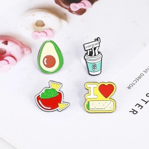 Detailed view of four cute avocado and food enamel pins set on a white background