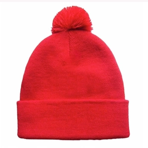 Classic red knitted beanie hat with a matching pompom top for winter outdoor warmth