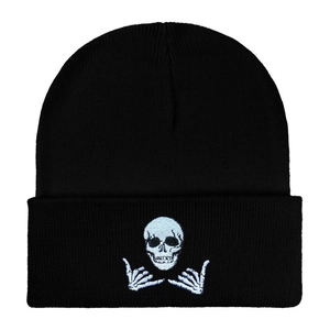 Close-up of white skull and skeleton hands embroidery on black knit beanie hat