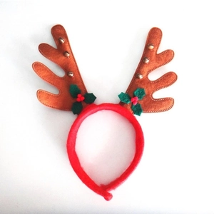 Detail of Christmas reindeer antlers headband with golden bells and holly leaves