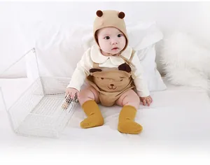 Close-up of baby warm outfit with brown bear hood and mustard ribbed socks
