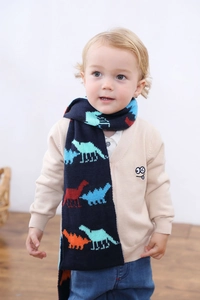 Détail d'une écharpe en maille bleu marine avec dinosaures colorés pour enfant