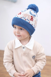 Close-up of children's blue knit dinosaur hat with red reindeer pattern and cotton lining