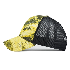 Detail view of tie-dye trucker hat showing breathable black mesh and graffiti patterns