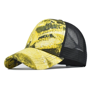 Close-up of yellow tie-dye mesh trucker hat with breathable black net and stable stitching