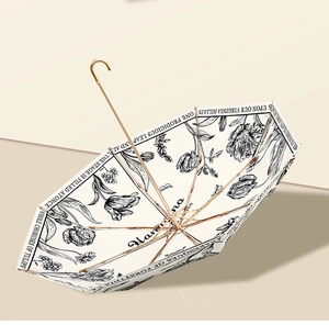 Macro detail of French vintage double-layer umbrella with floral prints and golden handle