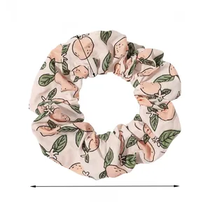 Pink fabric scrunchie with peach pattern showing dimensions of 4 inches and 6g weight