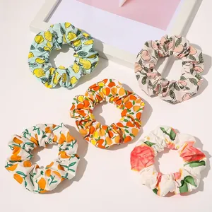 Detailed flat lay of 5-pack fruit print scrunchies with lemon and peach patterns