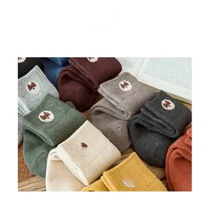 Detail of warm winter knit socks featuring cute animal embroidery and various colors