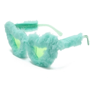 Detail of heart-shaped sunglasses with mint green plush fur trim and clear glitter temples
