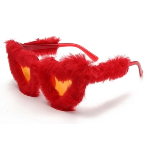 Macro shot of fluffy red faux fur texture and heart shaped frame of the party sunglasses