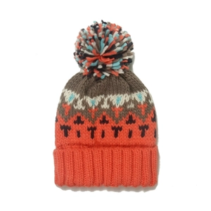 Detail of multi-color geometric mohair knit hat featuring a large soft pompom and rich texture