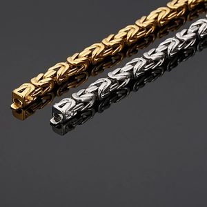Detailed macro view of gold and silver Byzantine link chains on a black reflective surface