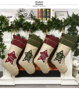 Set of 4 linen Christmas stockings with star patterns hanging on a decorated mantel