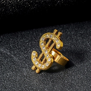 Macro shot of gold-plated dollar sign ring with sparkling rhinestones on black leather