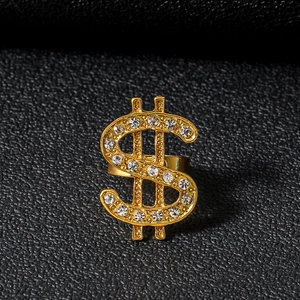 Macro detail of gold dollar sign ring with sparkling crystals on black texture