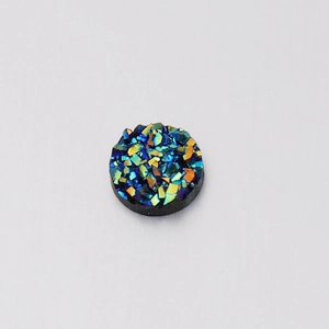 Macro detail of 6mm round resin druzy stone with blue and green iridescent surface