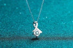 Macro detail of S925 sterling silver necklace with cross ribbon design and bright zircon