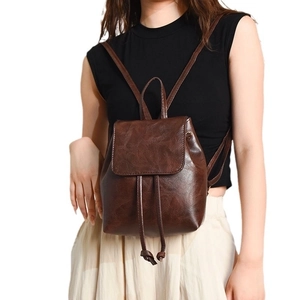 Minimalist vintage dark brown leather backpack with drawstring closure and flap cover