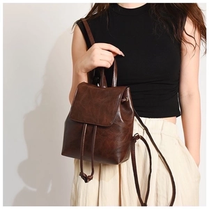 Detail shot of vintage brown PU leather mini backpack with drawstring and flap closure