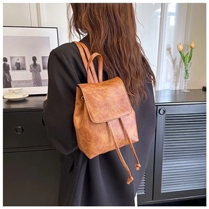 Close-up of vintage brown drawstring backpack with retro distressed faux leather texture
