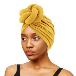 Close-up of bright yellow braided turban hat featuring soft knitted fabric and cross design