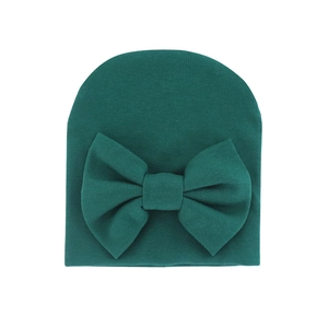Dark green knitted baby beanie with a large matching bow on a clean white background