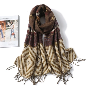 Detail of winter scarf showing rhombus pattern and tassel fringe in brown and beige