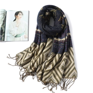 Detail of geometric rhombus pattern on warm navy scarf with decorative fringe borders