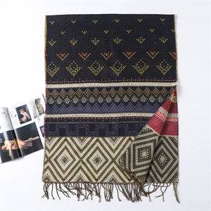 Detailed close-up of a blue geometric ethnic pattern scarf with elegant fringe trim edges