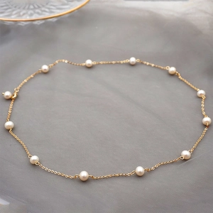 Elegant adjustable gold necklace with lustrous white freshwater pearls on a mesh surface