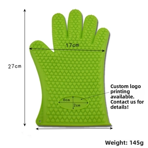 Detail of green silicone oven mitt showing heart-shaped anti-slip texture and hanging hole