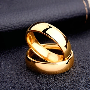 Polished 6mm gold titanium steel minimalist band rings on black leather background