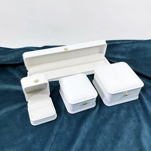 Macro view of white PU leather jewelry boxes with gold crown accents and velvet lining