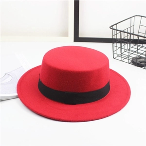 Close-up of red felt flat top hat featuring a stylish black decorative ribbon band