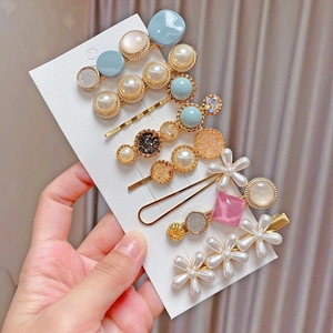 Close-up of 8-piece hair clip set with faux pearls, rhinestones, and floral charms