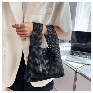 Detail of minimalist black rhinestone handbag with shimmering crystals on a soft tote