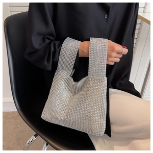 Detailed close-up of a silver rhinestone handbag featuring a sparkling woven texture