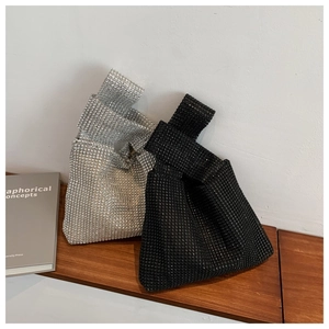 Sparkling rhinestone knot handbags in silver and black on a wooden shelf display
