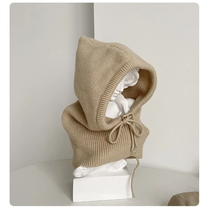 Detail of beige ribbed knit balaclava with drawstring on a white display stand