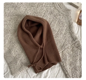 Detail of brown ribbed knit balaclava with drawstring on soft background
