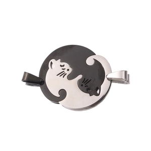 Detail of interlocking yin yang cat pendants in black and silver polished stainless steel