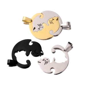 Detail of interlocking cat pendants in gold, silver and black stainless steel
