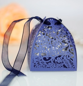 Macro shot of purple hollow-carved gift box with elegant blue ribbon handle